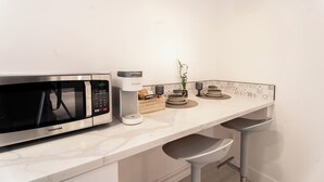 A kitchen with a stainless steel microwave, a Keurig coffee maker, and a small plant on the counter. - 'The Sweet Pad' - Cozy Studio with WiFi and AC in lovely Ojai (Ojai)