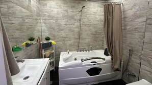 A modern bathroom with a bathtub, shower, and toilet. - Charming 2-bed Apartment in Baku City Center (Baku)