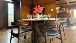 A dining area with a wooden table set for four, surrounded by chairs. - The Colonial Mt. Lebanon by Luxe PGH (Pittsburgh)