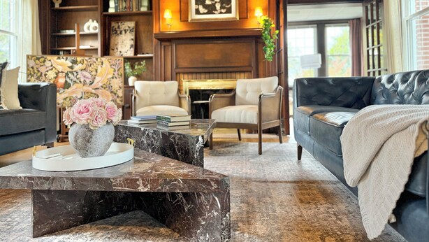 A cozy living room with a fireplace, bookshelves, and comfortable seating. - The Colonial Mt. Lebanon by Luxe PGH (Pittsburgh)