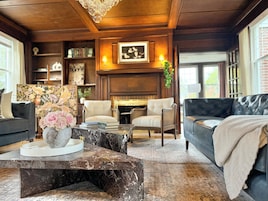 A cozy living room with a fireplace, bookshelves, and comfortable seating.