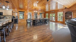 Una cabaña de madera espaciosa con un amplio comedor, cocina y asientos de bar.