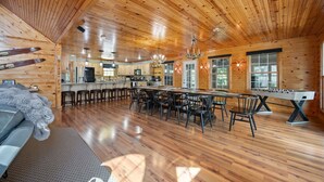 Una cabaña de madera espaciosa con un amplio comedor, cocina y una zona de estar acogedora.