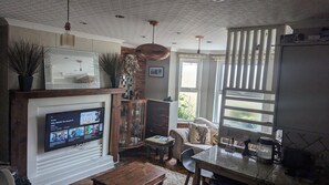 Relax in this inviting living area with a TV, cabinet, and comfortable seating.