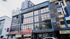 A multi-story building with a sign reading 'HOTEL 99' at the top.
