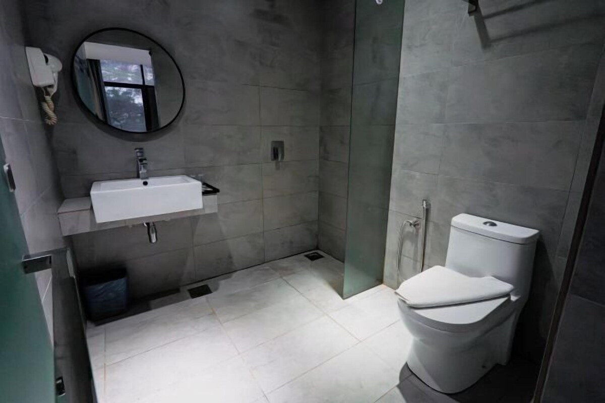 Une salle de bain moderne avec un lavabo blanc, un miroir et des toilettes.