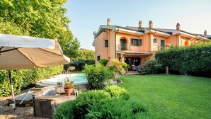 A house with a swimming pool, a patio with a table and chairs, and a well-maintained garden. - The Aurora's Nest (Belvedere Lidia)