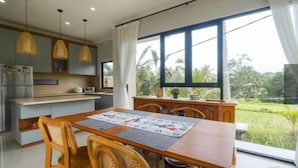 Una cocina moderna con comedor, ventanas amplias y vista a zonas verdes.