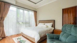 Un dormitorio con cama, una silla y una ventana con cortinas.