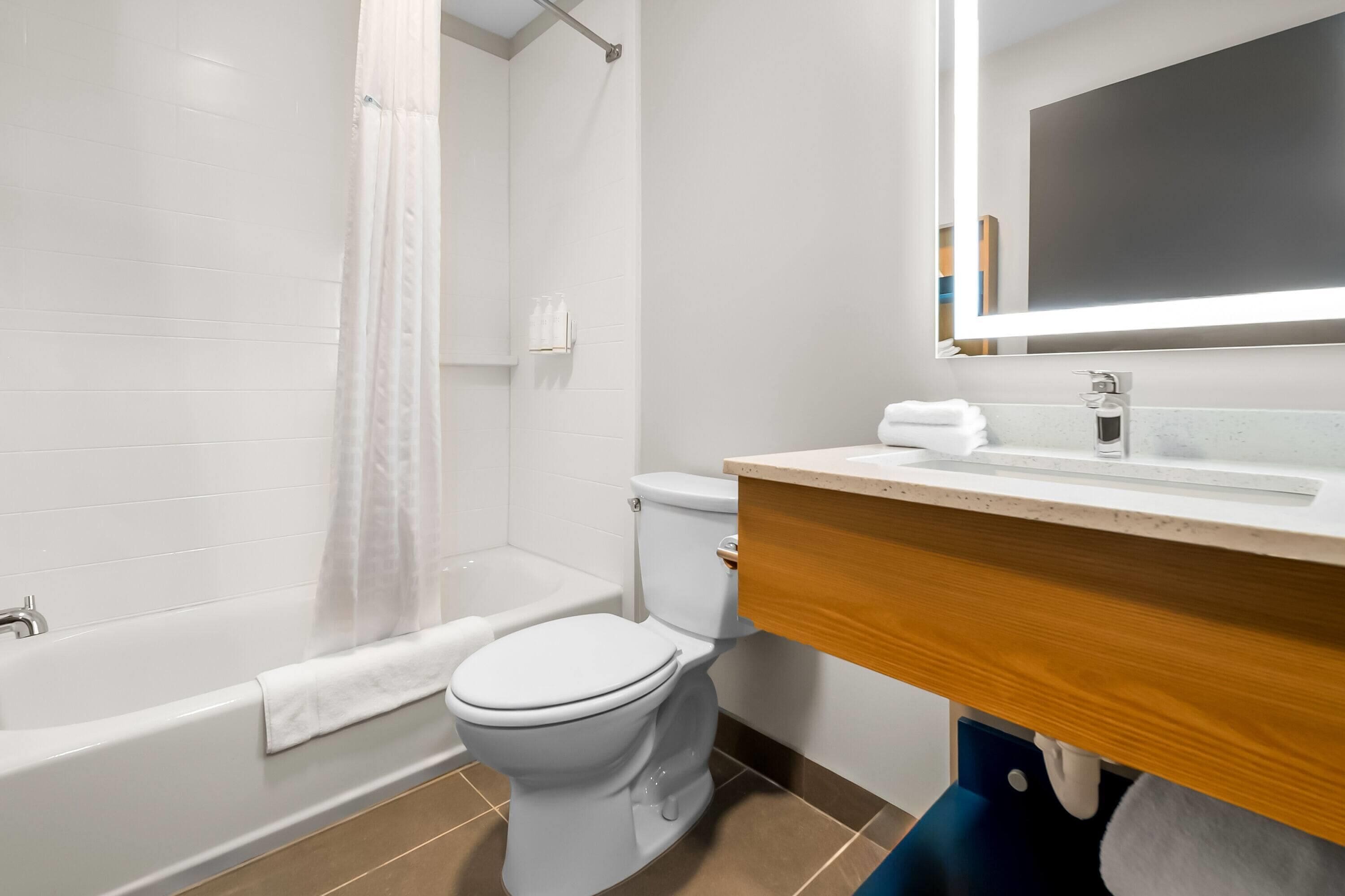 A bathroom with a bathtub, toilet, and sink.