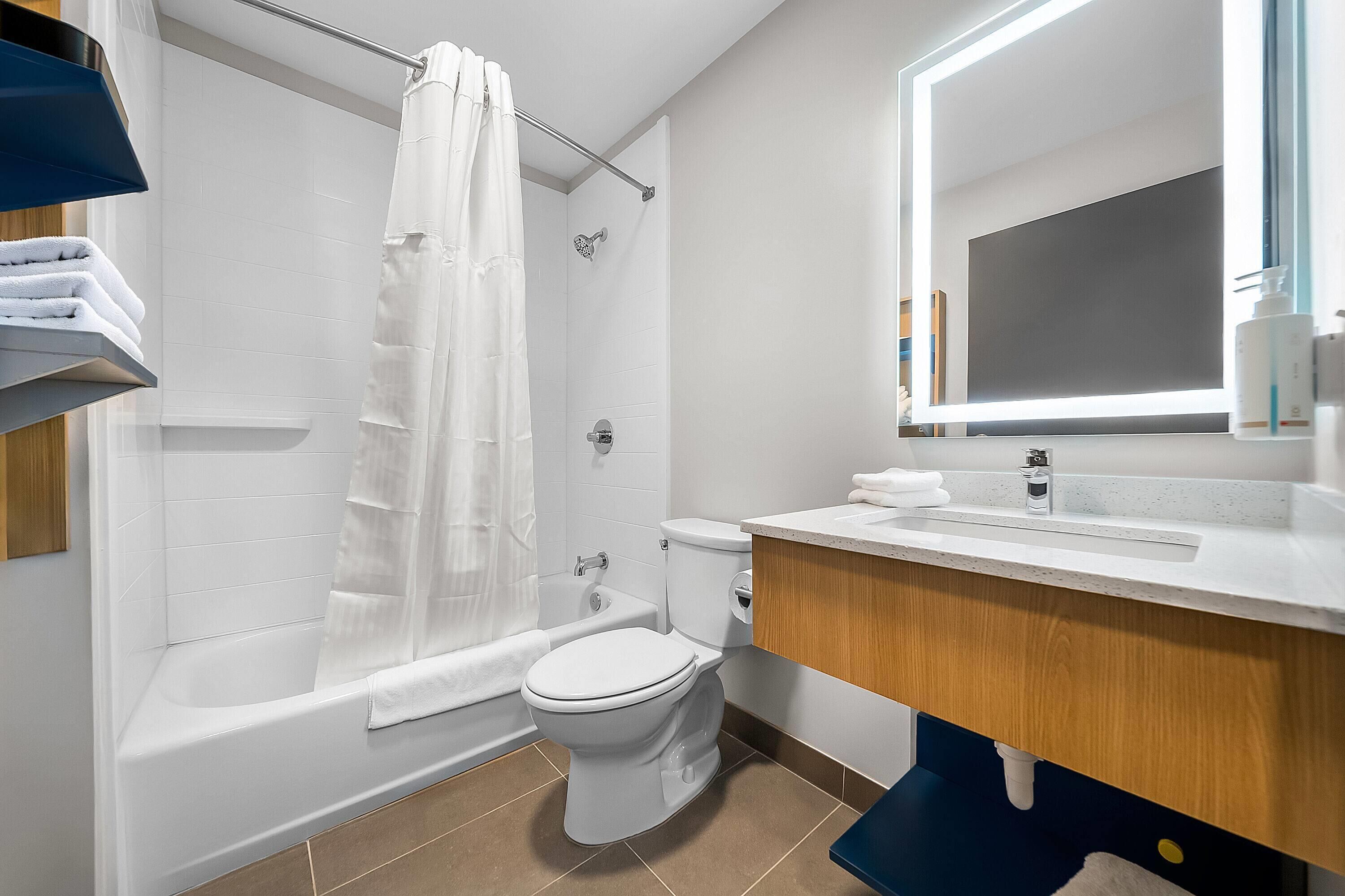A modern bathroom with a bathtub, toilet, and sink.