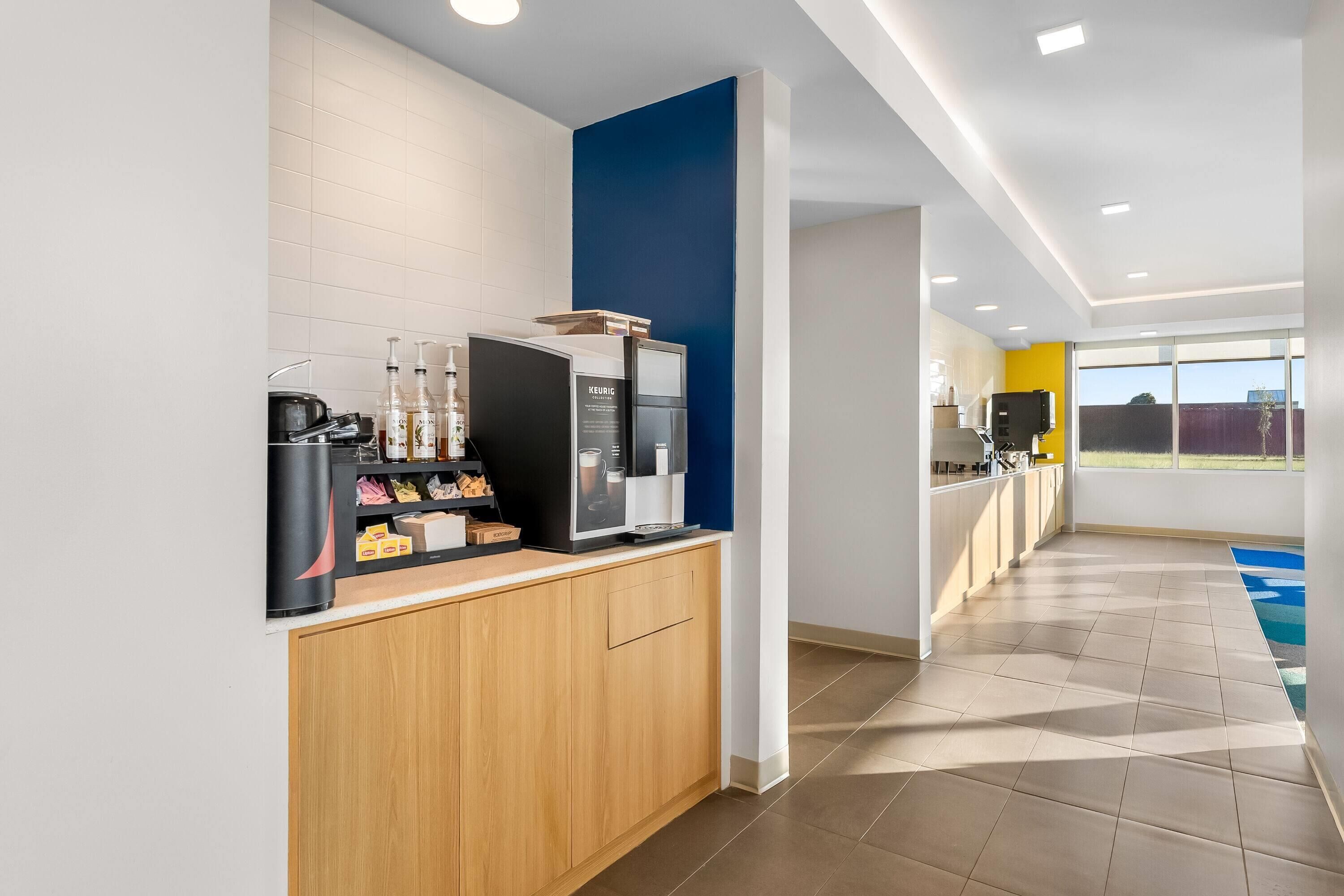 A modern kitchen with a coffee machine, a microwave, and a sink.