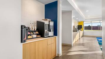 A modern kitchen with a coffee machine, a microwave, and a sink.