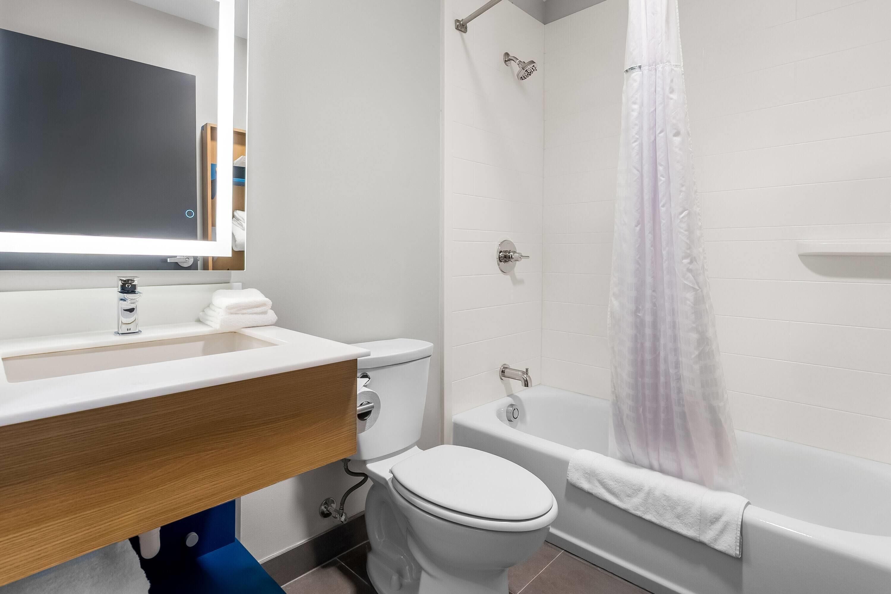 A modern bathroom with a white sink, toilet, and bathtub.