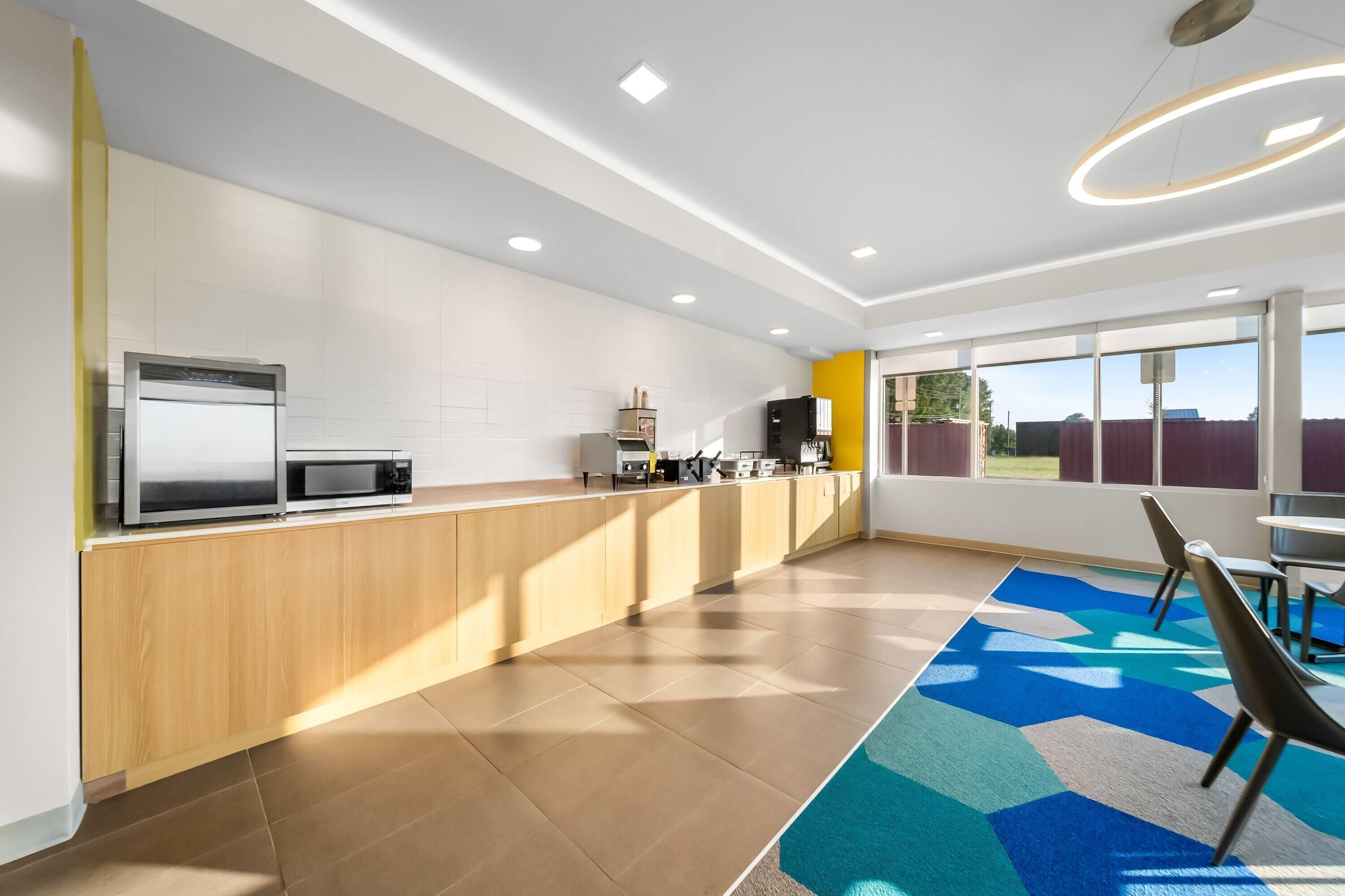 A modern kitchen with a microwave, coffee machine, and a refrigerator.