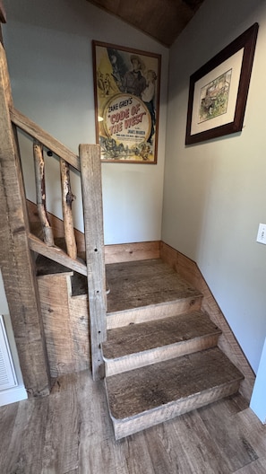 A wooden staircase with a rustic design, leading to a landing area.