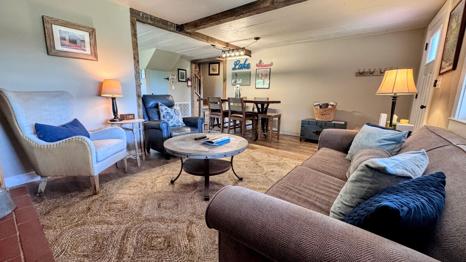 A cozy living room with a fireplace, a dining area, and a staircase leading to another level.