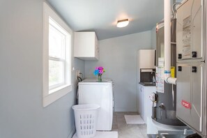 A compact laundry room with a washing machine, dryer, and stacked appliances. - Rare 12-Guest Cabins w/ Hot Tubs, Fire Pits & Pets (Mariposa)