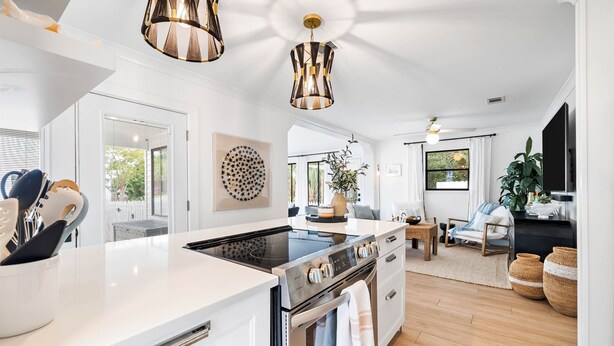 A modern kitchen with a central island, stainless steel appliances, and pendant lighting. - Charming Blue Mountain Bungalow in 30A. Walk or Golf Cart down to the sand.  (Santa Rosa Beach)