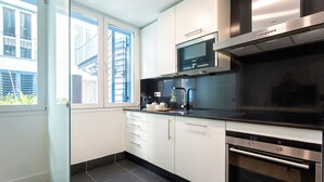 A modern kitchen with a built-in oven, microwave, and coffee maker.