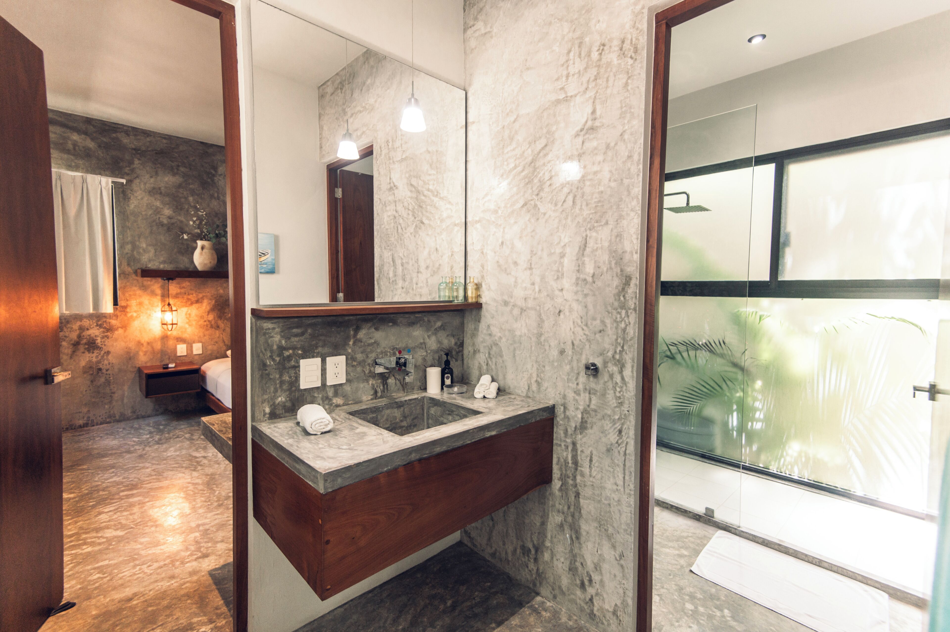 A modern bathroom with a marble sink, wooden vanity, and a large mirror.