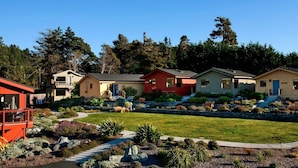 Una hilera de casas de un piso con un césped y jardín bien cuidados al frente.