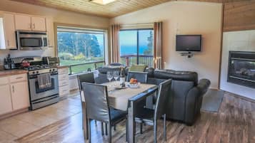 Una cocina moderna con comedor, televisor de pantalla plana y chimenea.