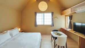 A hotel room with a large bed, a desk with a chair, a television, and a window with curtains. - Reikyo Garden Osaka (Osaka)