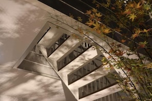 A spiral staircase with a modern design, surrounded by foliage. - Reikyo Garden Osaka (Osaka)