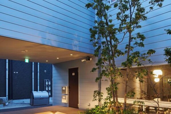 A modern building with a covered outdoor area, a reception desk, and a seating area.
