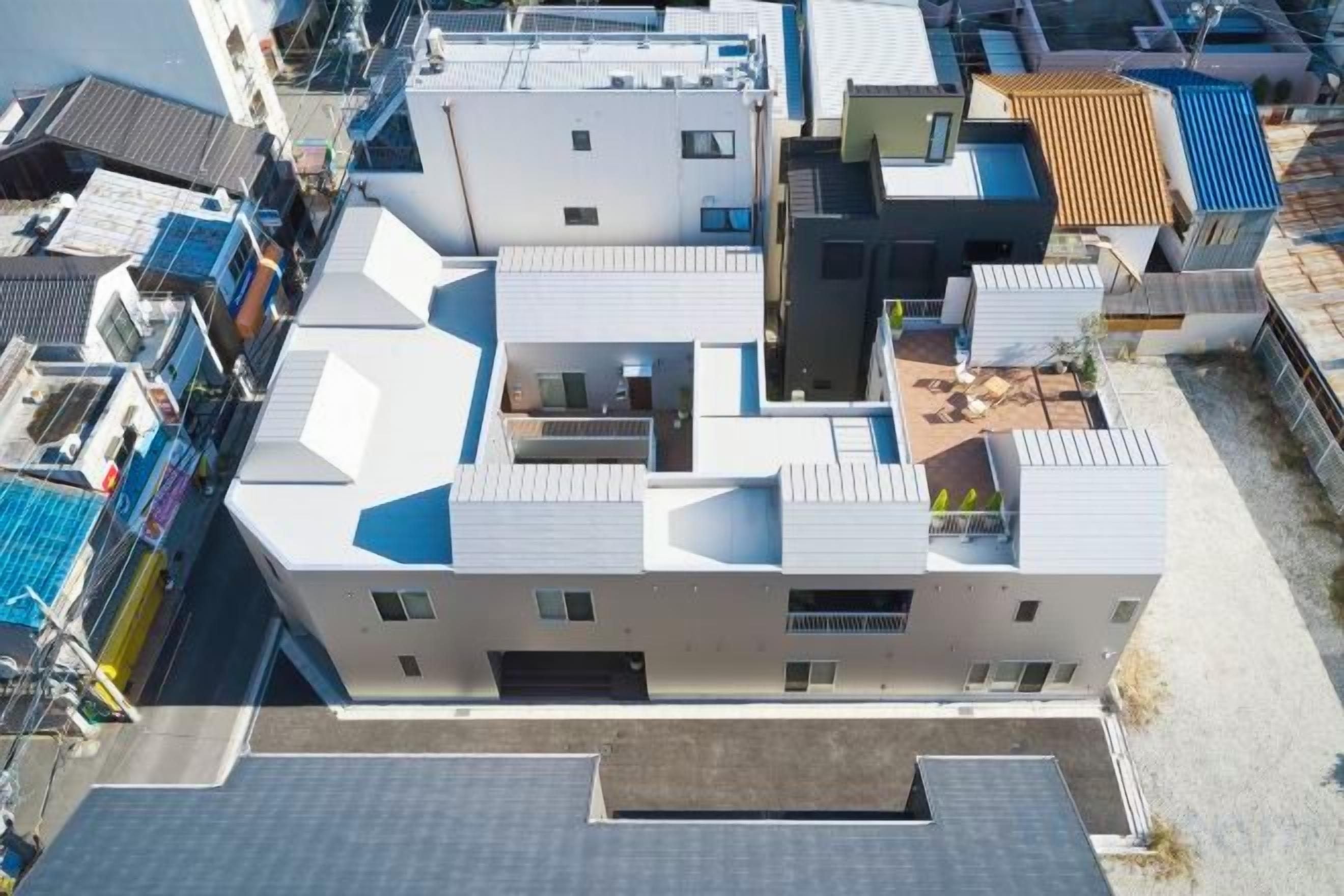A multi-story building with a flat roof, multiple balconies, and a central courtyard.