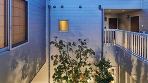 A modern building with a balcony, a small window, and a tree in front. - Reikyo Garden Osaka (Osaka)