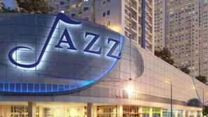 A building with a large illuminated 'JAZZ' sign on its facade. - Your home away from home! (Makati City)