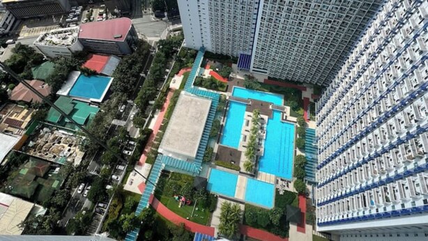 A high-rise building with multiple balconies and a rooftop pool area. - Your home away from home! (Makati City)
