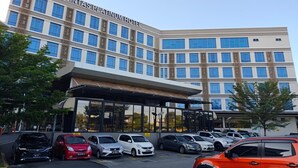 A modern hotel building with a large parking lot. - Lintas Platinum Hotel (Kota Kinabalu)