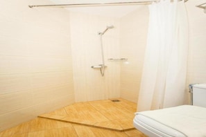 A small, enclosed shower area with a showerhead and a toilet. - Lintas Platinum Hotel (Kota Kinabalu)