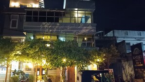 A modern building with multiple floors, illuminated windows, and a sign for Lacozy Hotel. - La Cozy Hotel & Restaurant (Negombo)