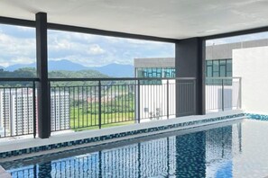 Una piscina con vistas a un paisaje urbano y montañas.