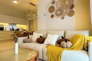 A living room with a sofa, a round table, and decorative wall art. - The Horizon Ipoh By Iconique Espace (Ipoh)