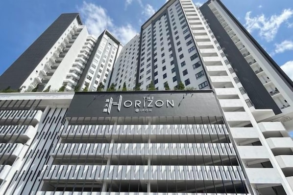A high-rise building with a prominent 'Horizon' sign, multiple balconies, and a modern architectural design.