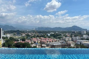 A cityscape with a pool area and buildings in the background.