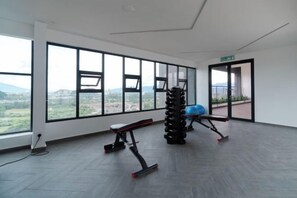A gym with exercise equipment, large windows, and a view of the outdoors. - The Horizon Ipoh By Iconique Espace (Ipoh)