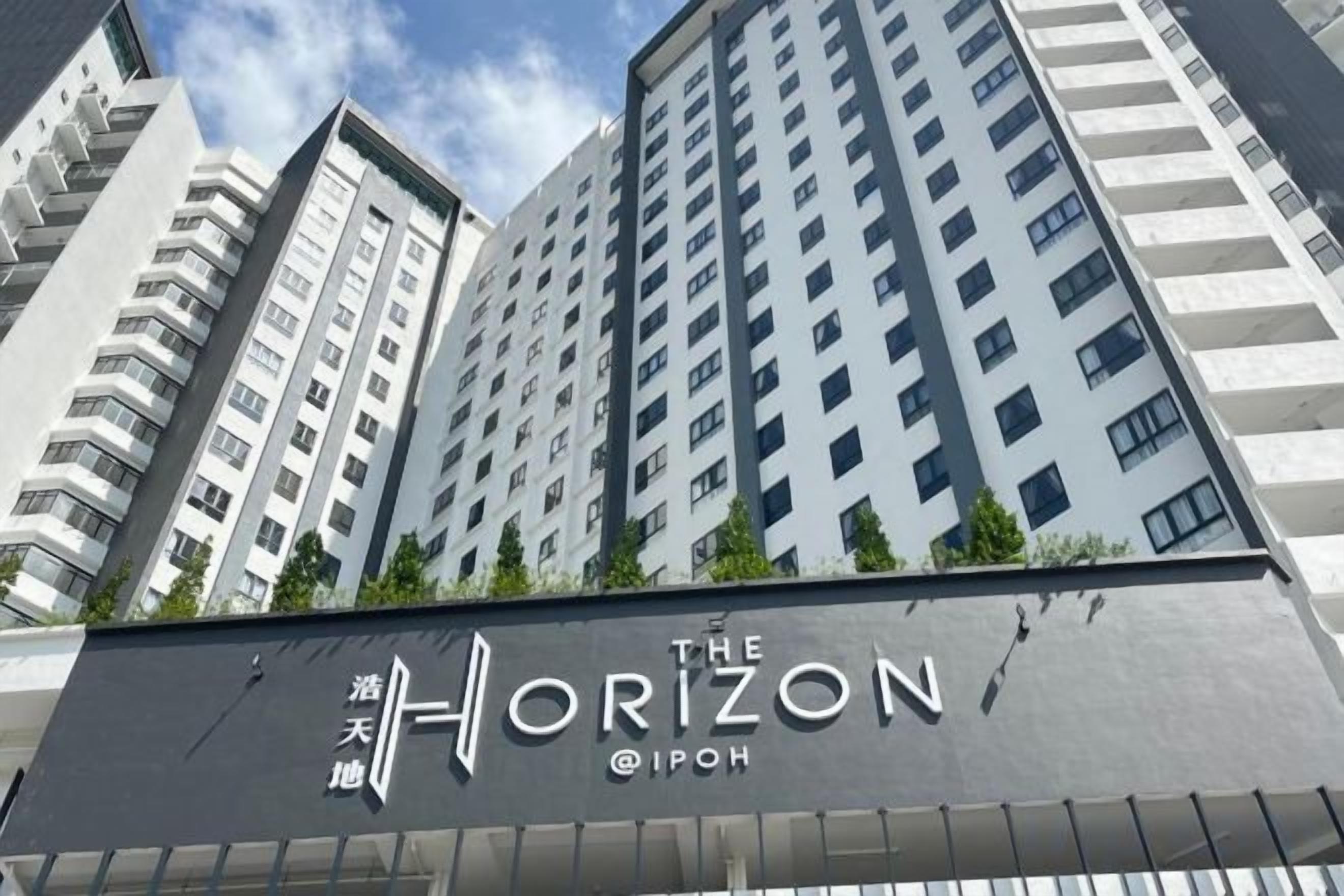 Um edifício alto com uma placa indicando 'The Horizon @IPOH'.