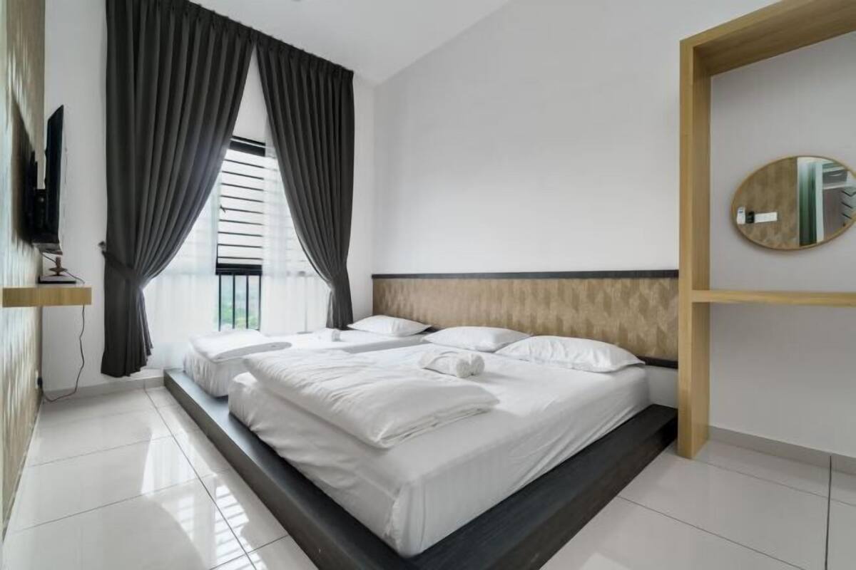 A modern hotel room with a large bed, a television, and a view of the outdoors.