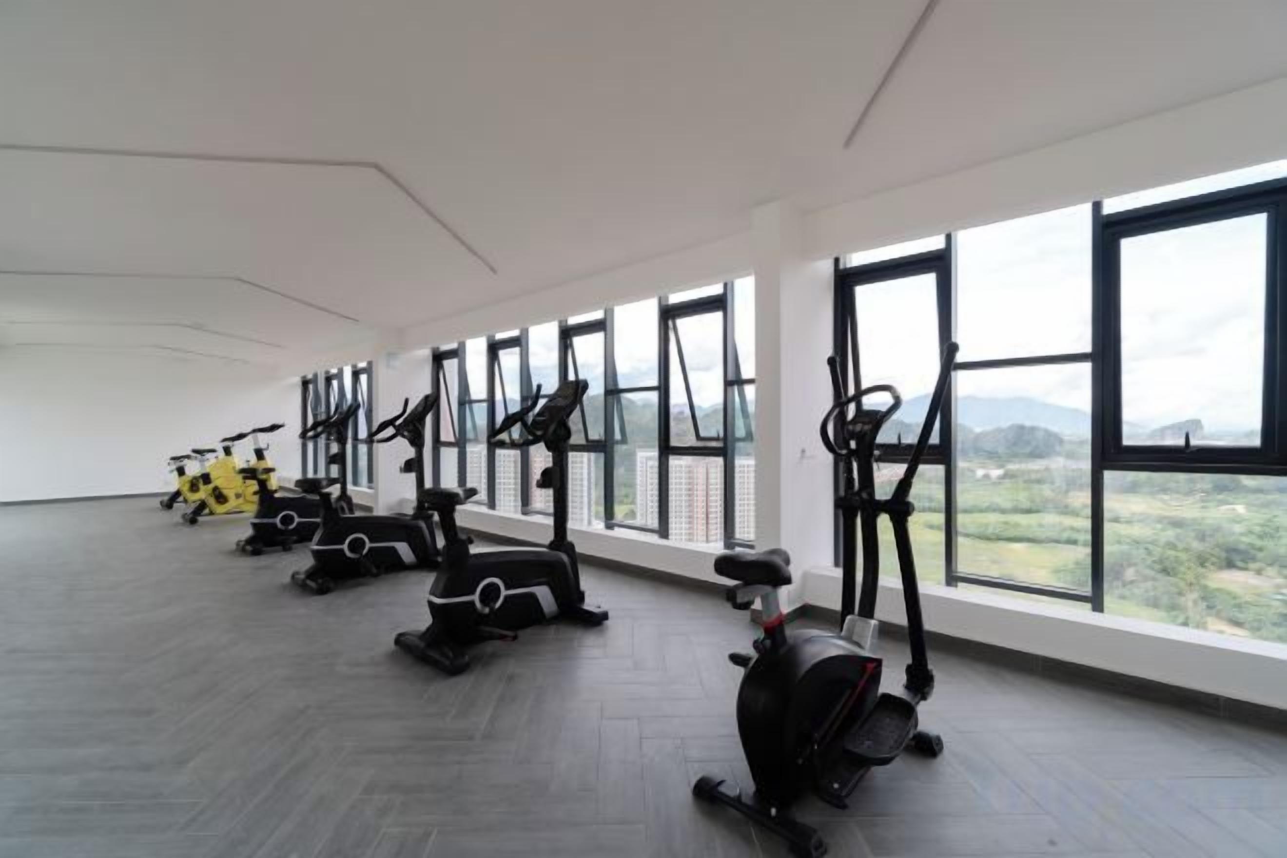 A gym with exercise equipment and large windows.