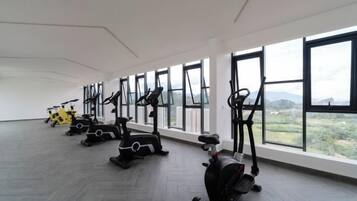 A gym with exercise equipment and large windows.