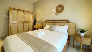 A bedroom with a bed, bedside table, and a wardrobe.