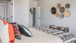 A bedroom with a bed, pillows, a bench, and wall decor. - Zion's Premier Getaway for the entire family!  (Hurricane)