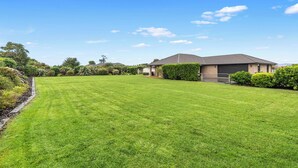 Une propriété résidentielle dotée d’une pelouse bien entretenue, d’un garage et d’une maison avec un toit en pente.