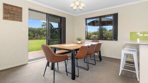 Un espace repas comprenant une table et des chaises, une plante en pot et une vue sur l’extérieur.